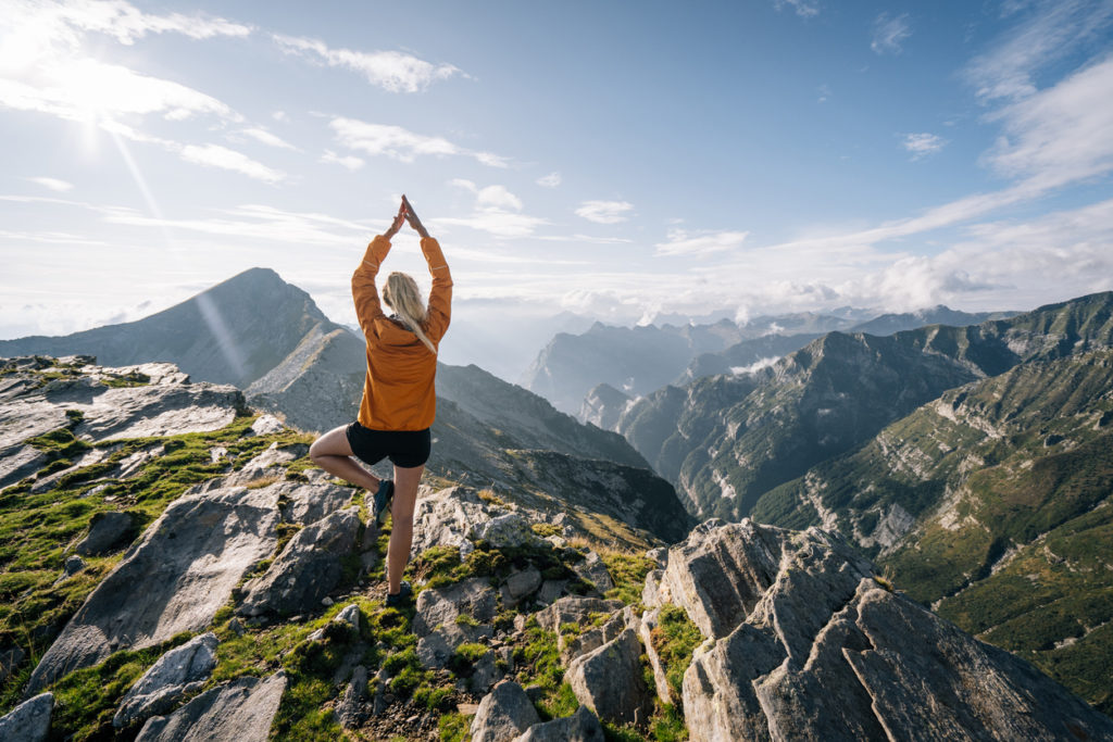 Young Woman Preforms Yoga In Mountains In Morning Light